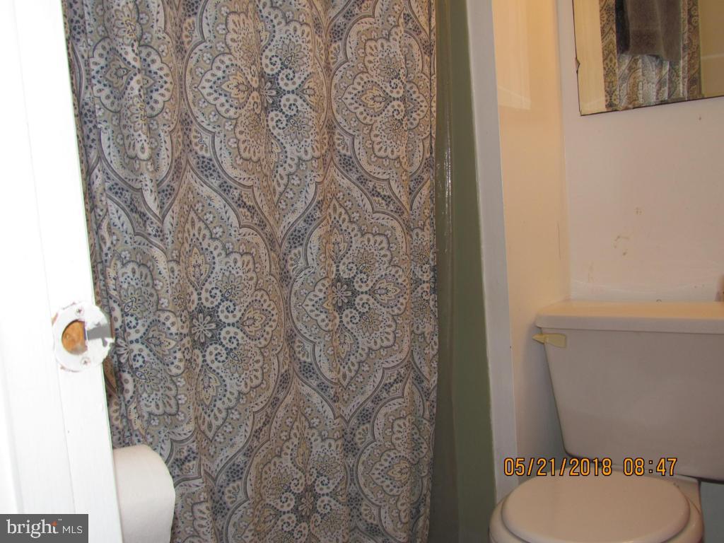 38 Sandyhook Road Ocean Pines, MD 21811 - Photo 19 of 33 a white toilet sitting next to a shower curtain