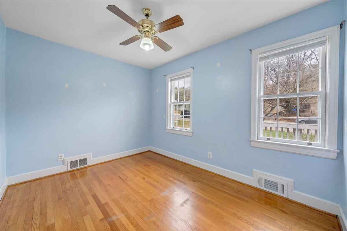 910 Brandon Avenue Southwest Roanoke, VA 24015 - Photo 18 of 50 a view of an empty room with a window and wooden floor