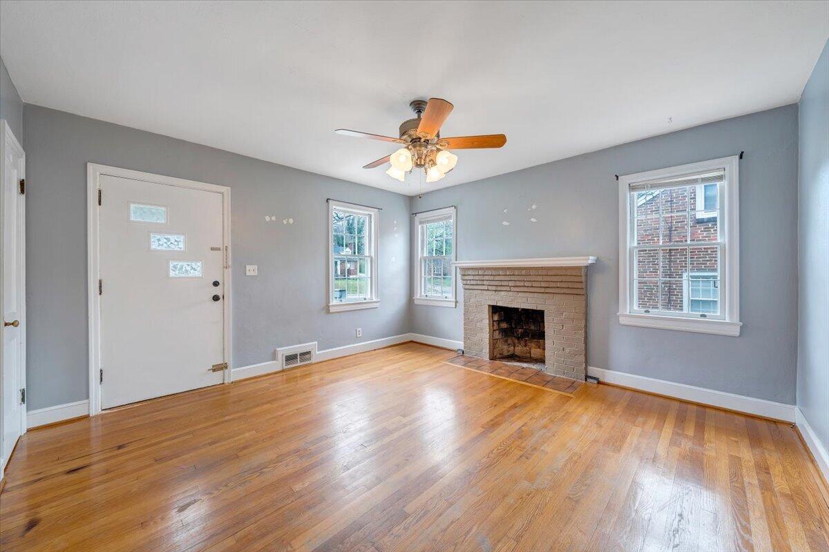 910 Brandon Avenue Southwest Roanoke, VA 24015 - Photo 4 of 50 an empty room with windows and fireplace