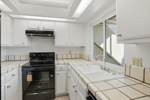 a kitchen with a sink stove and cabinets