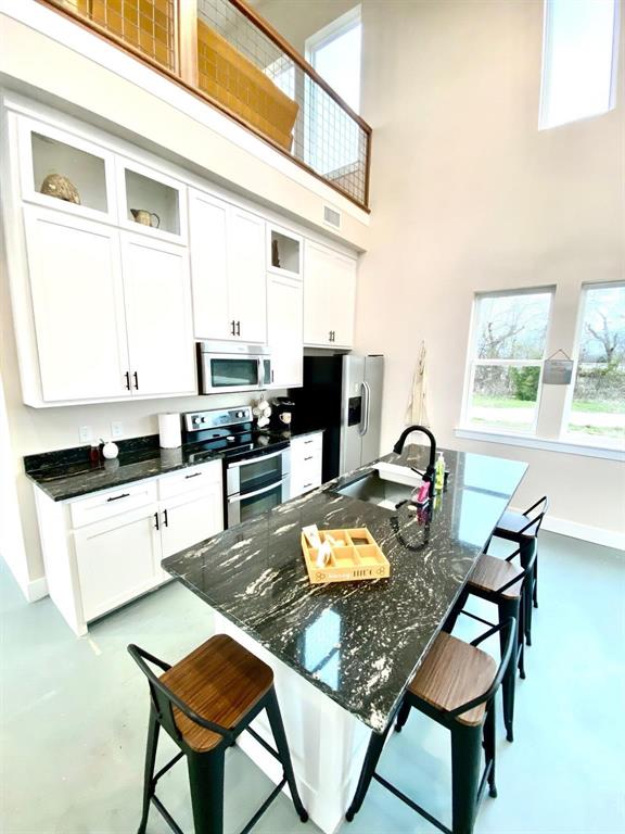 4302 Fm 2862, Unit B Anna, TX 75409 - Photo 4 of 13 a kitchen with a dining table chairs and white appliances