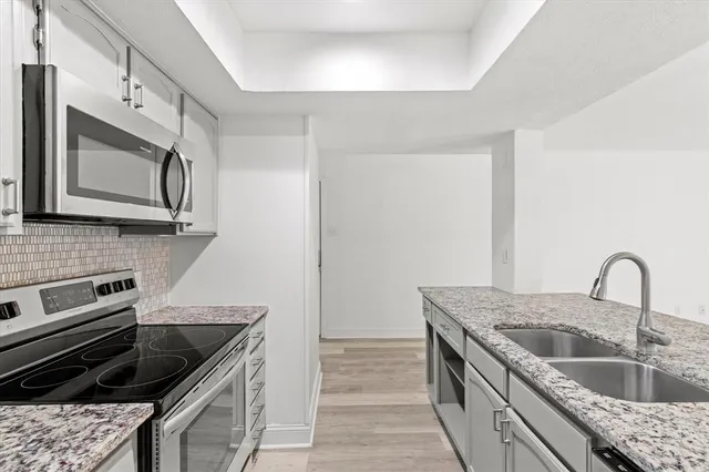 a kitchen with granite countertop a sink and a stove top oven