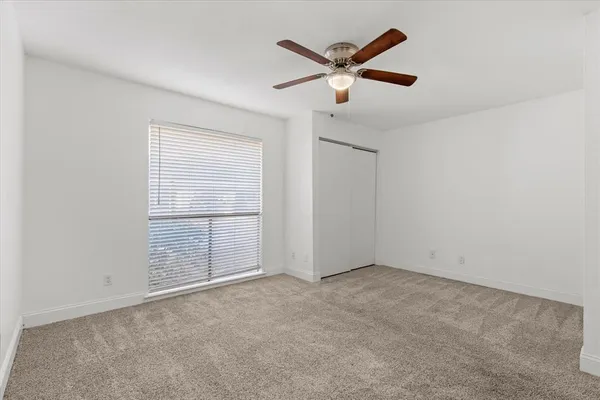 an empty room with closet and fan