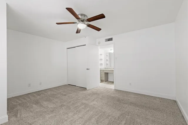 an empty room with closet and ceiling fan