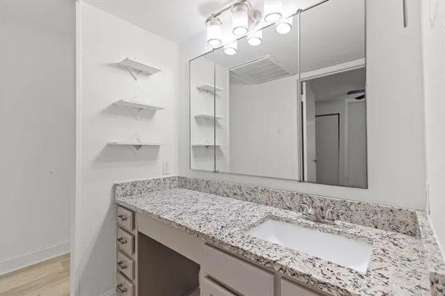 a bathroom with a granite countertop sink and a mirror
