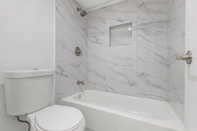 a white toilet and tub sitting next to a bathroom sink