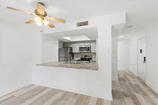 a view of a kitchen with a sink cabinets and wooden floor