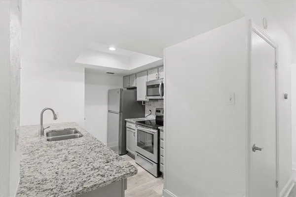 a kitchen with stainless steel appliances granite countertop a sink stove and refrigerator