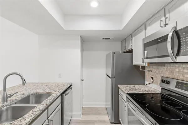 a kitchen with stainless steel appliances granite countertop a sink stove and refrigerator