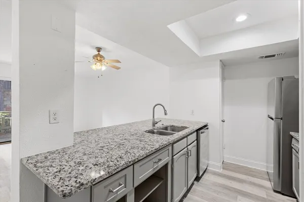 a utility room with kitchen island stainless steel appliances and wooden floor