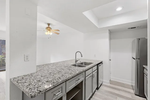 a utility room with kitchen island stainless steel appliances and wooden floor