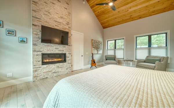 740 Chestnut Mountain Road Blairsville, GA 30512 - Photo 28 of 75 a bedroom with a bed and a fireplace