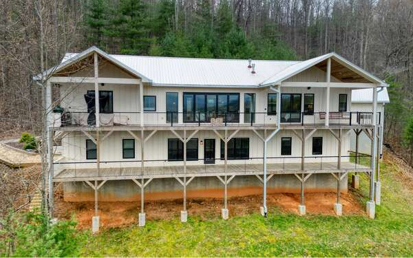 740 Chestnut Mountain Road Blairsville, GA 30512 - Photo 54 of 75 a view of a white house with large windows and a yard