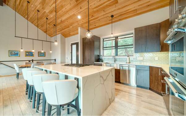 740 Chestnut Mountain Road Blairsville, GA 30512 - Photo 7 of 75 a kitchen with a stove a sink a kitchen island with chairs and wooden cabinets