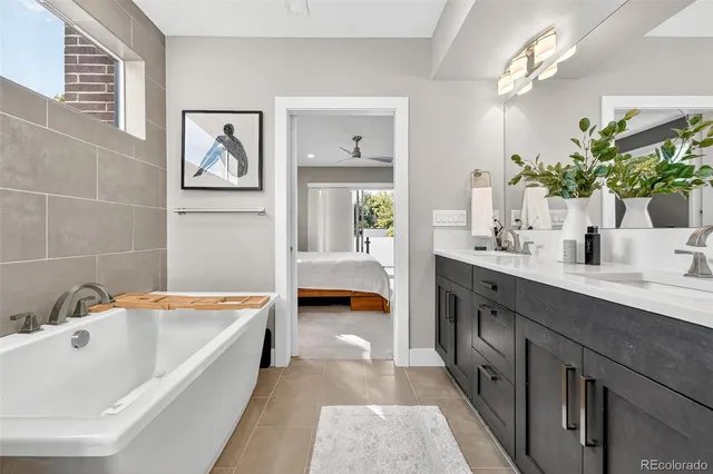 a bathroom with a tub double sink and two large mirror