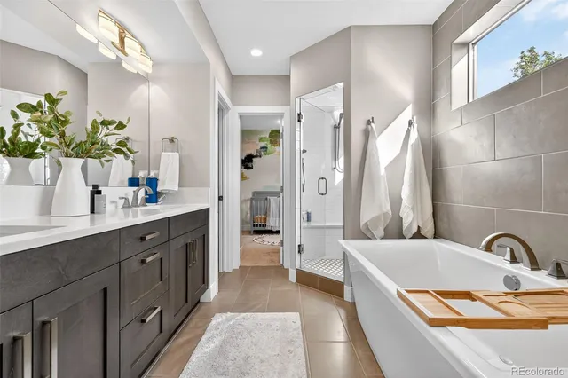 a spacious bathroom with a tub sink and mirror