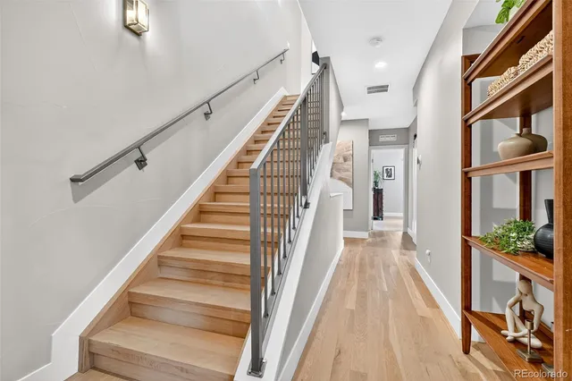 a view of staircase with lots of frames on wall and windows