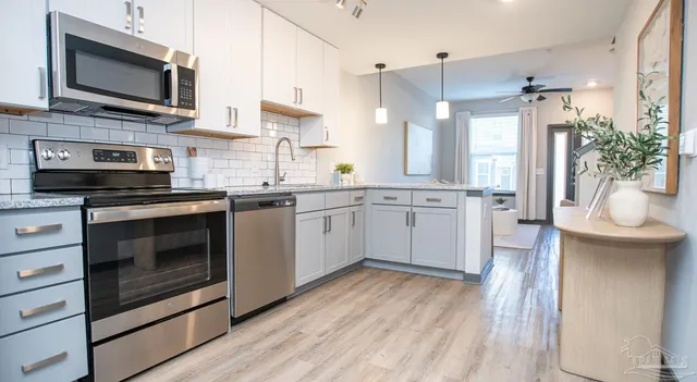a kitchen with stainless steel appliances a stove a sink and a microwave