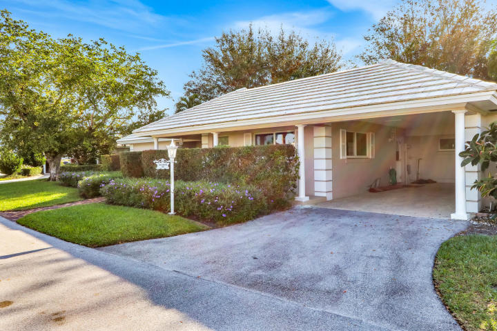 a view of a house with a yard and potted plants