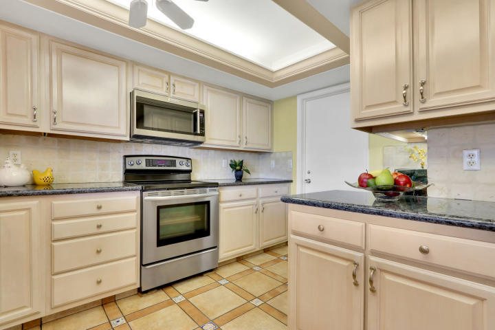 434 French Royale Circle Atlantis, FL 33462 - Photo 7 of 17 a kitchen with granite countertop white cabinets stainless steel appliances and sink