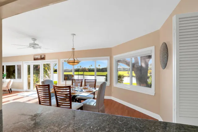 a dining room with furniture large windows and wooden floor