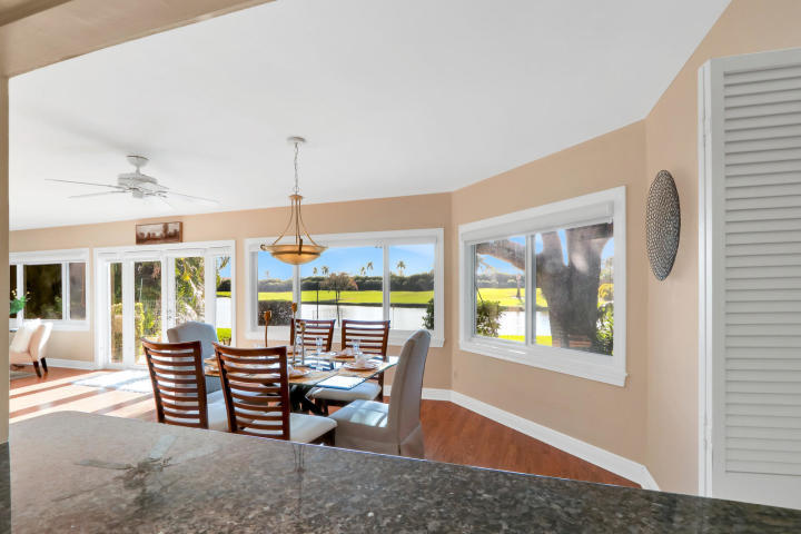 434 French Royale Circle Atlantis, FL 33462 - Photo 8 of 17 a dining room with furniture large windows and wooden floor