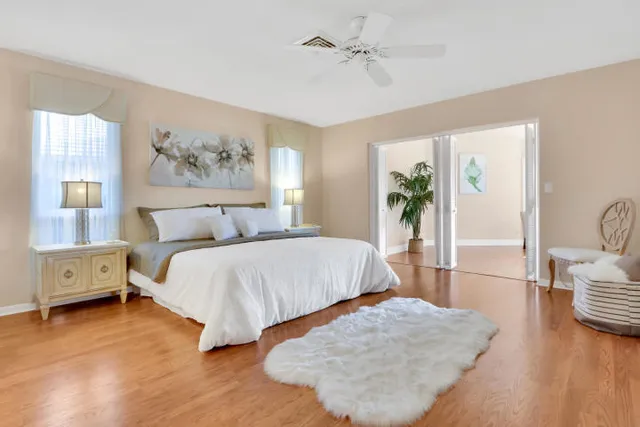 a spacious bedroom with a bed and wooden floor