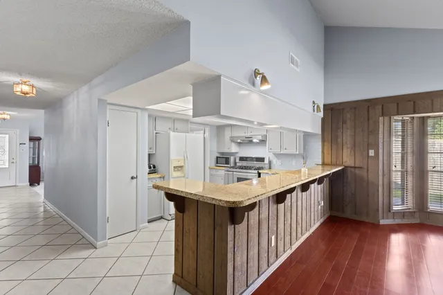 a kitchen with stainless steel appliances a sink and a wooden floor