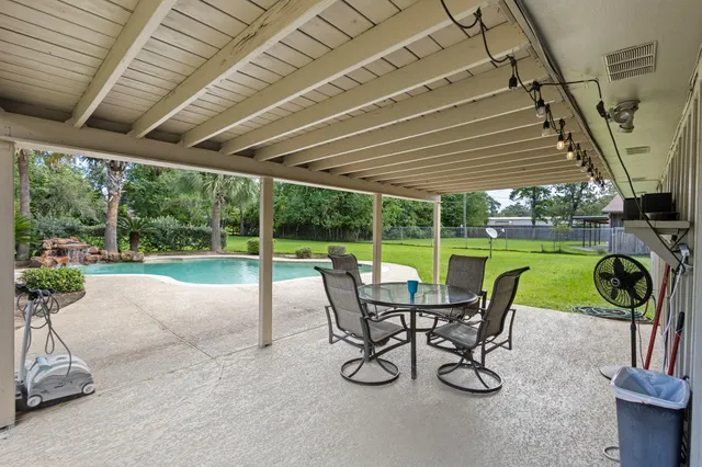 a view of a patio with a table chairs and a backyard