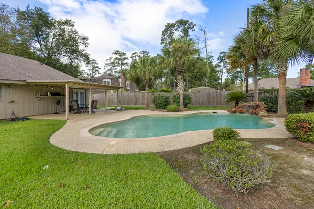 a view of a house with a backyard and a tree