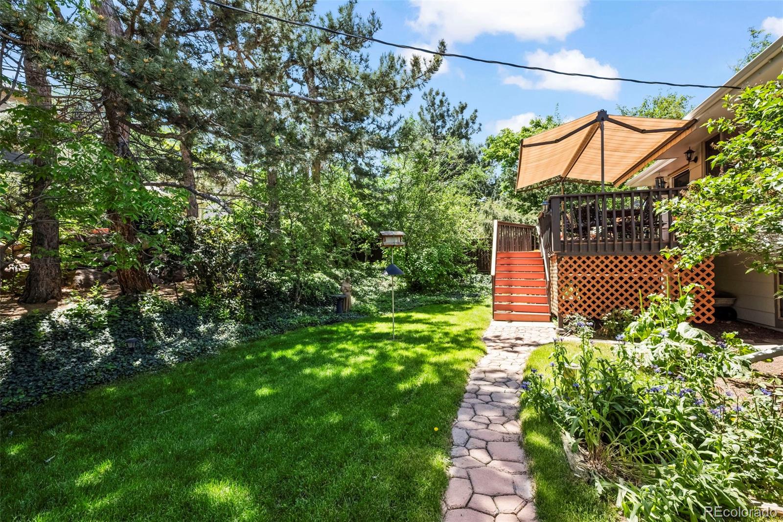 1560 Findlay Way Boulder, CO 80305 - Photo 34 of 40 a backyard of a house with lots of green space and glass windows