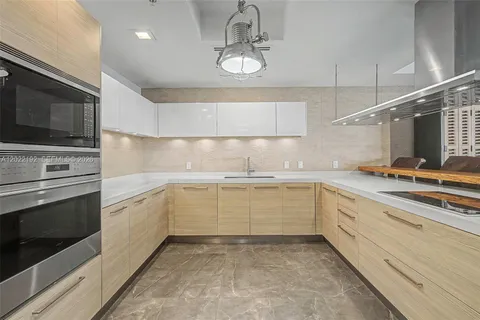 a kitchen with granite countertop cabinets stainless steel appliances and a counter space
