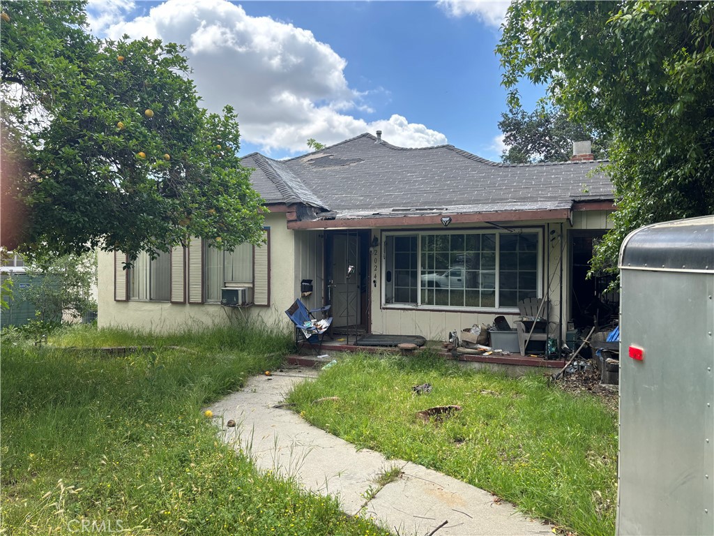 a view of a house with a yard and sitting area