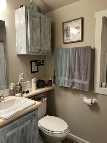 a bathroom with a sink a toilet and mirror