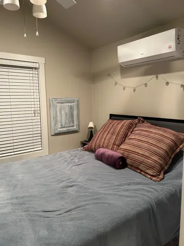 a bedroom with a bed and painting on the wall