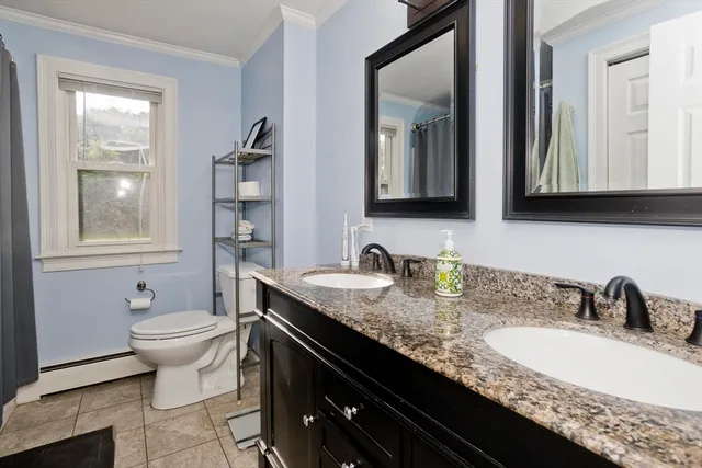 a bathroom with a granite countertop sink a toilet and mirror