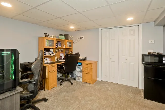 a view of a workspace with furniture and a refrigerator