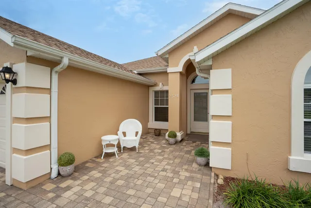 a backyard of a house with table and chairs