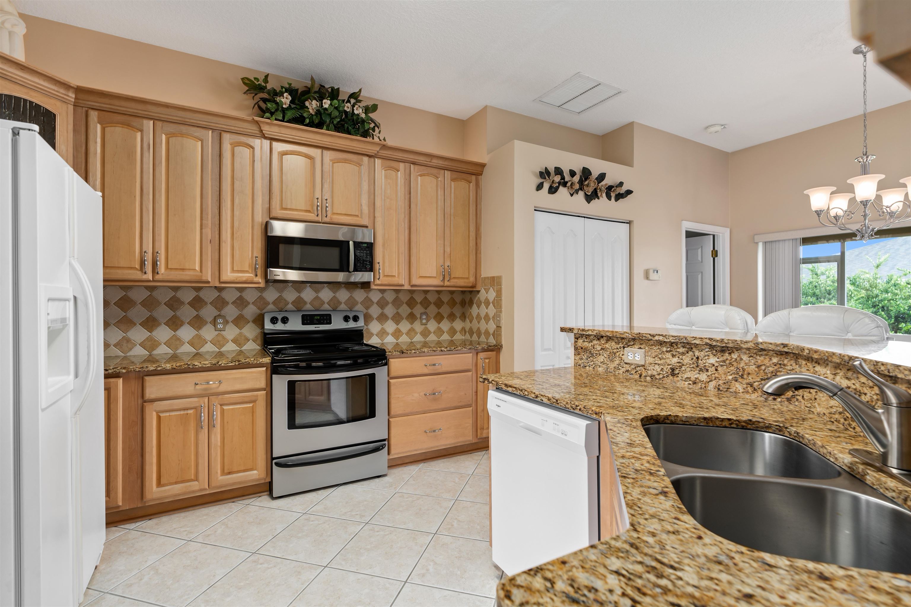 2325 Commodores Club Boulevard St. Augustine, FL 32080 - Photo 7 of 38 a kitchen with kitchen island granite countertop a sink and stainless steel appliances