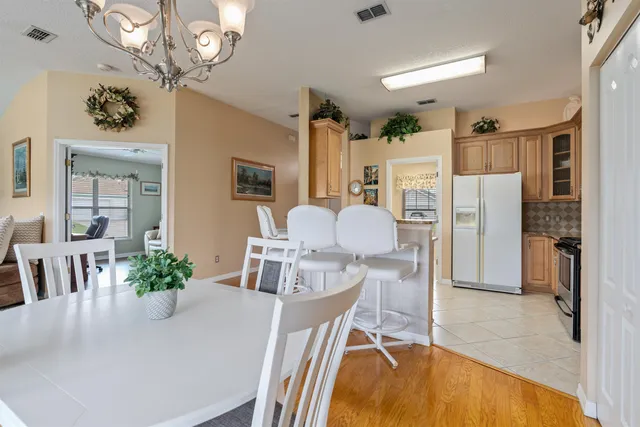 a dining room with furniture a chandelier and wooden floor
