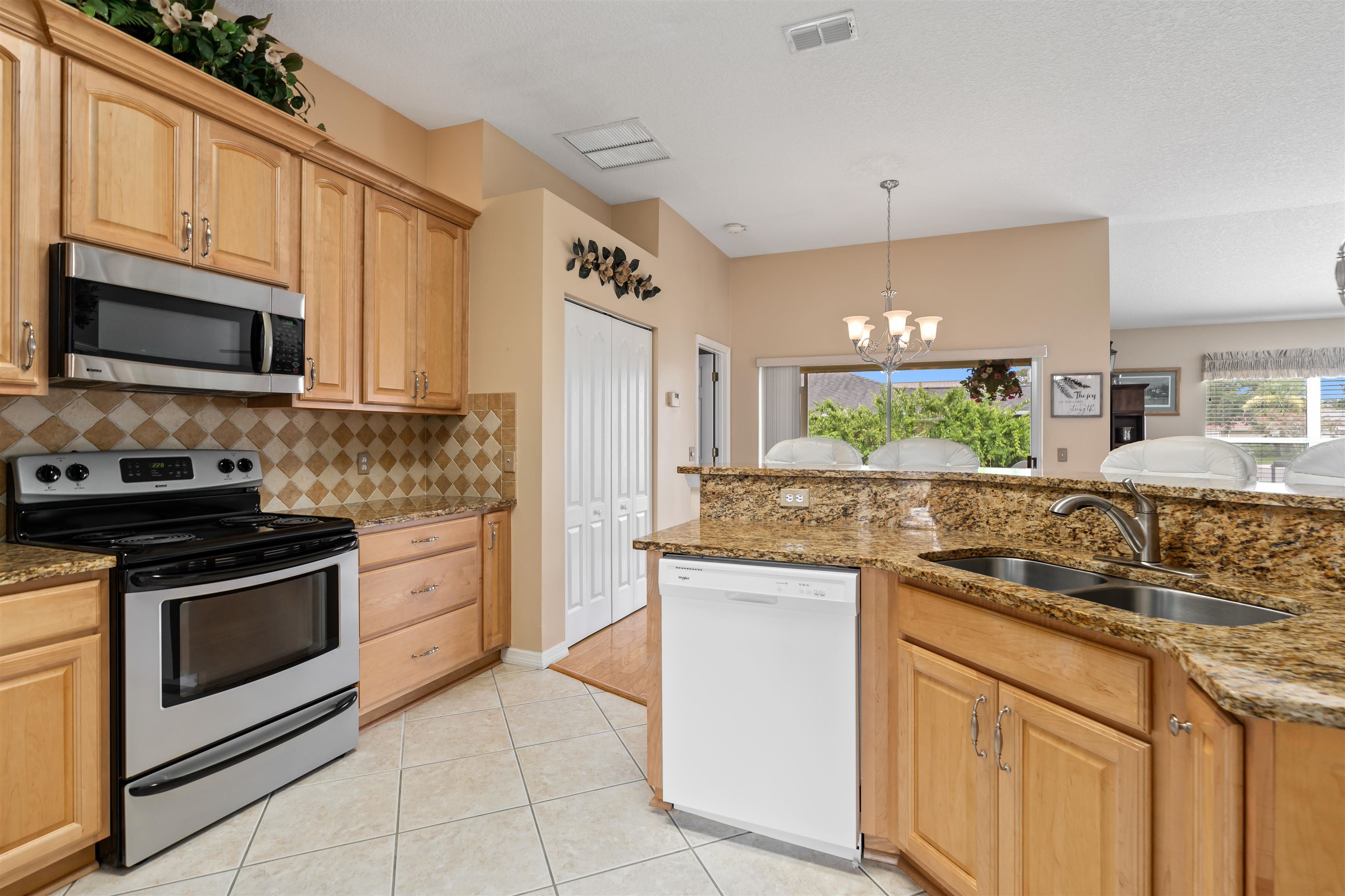 2325 Commodores Club Boulevard St. Augustine, FL 32080 - Photo 9 of 38 a kitchen with granite countertop a sink stove and microwave