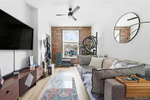 a living room with furniture a flat screen tv and a large window