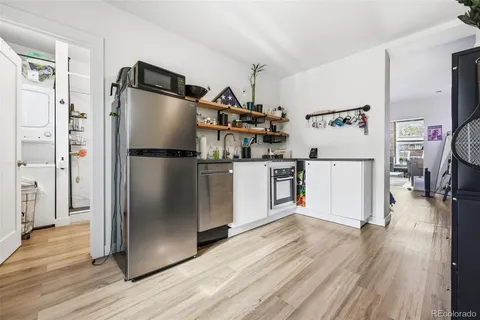 a kitchen with stainless steel appliances a refrigerator and wooden floor