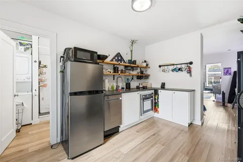 a kitchen with a refrigerator and wooden floor