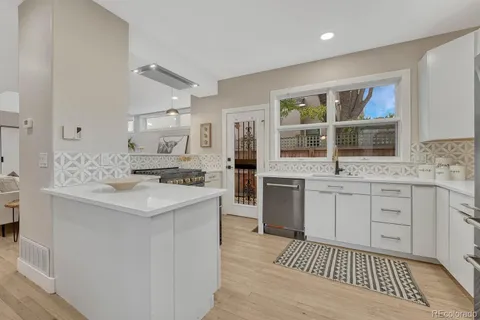 a kitchen with white cabinets a sink and a window