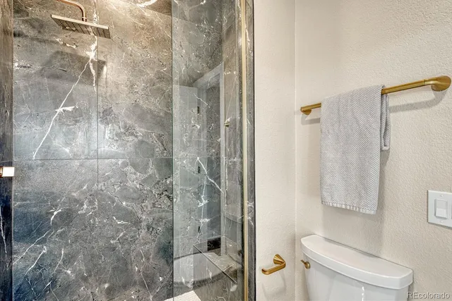 a spacious bedroom with a bed a table and a painting on the wall