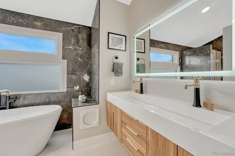 a bathroom with bathtub sink and mirror