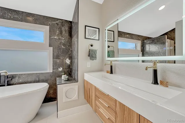 a bathroom with bathtub sink and mirror