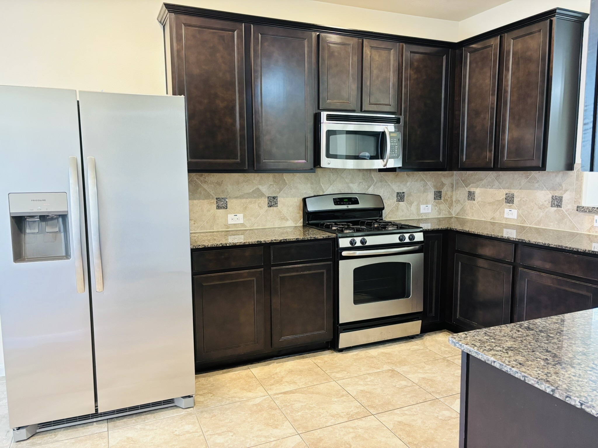 8525 Sunset Loch Drive Spring, TX 77379 - Photo 4 of 28 a kitchen with stainless steel appliances granite countertop a refrigerator stove and sink