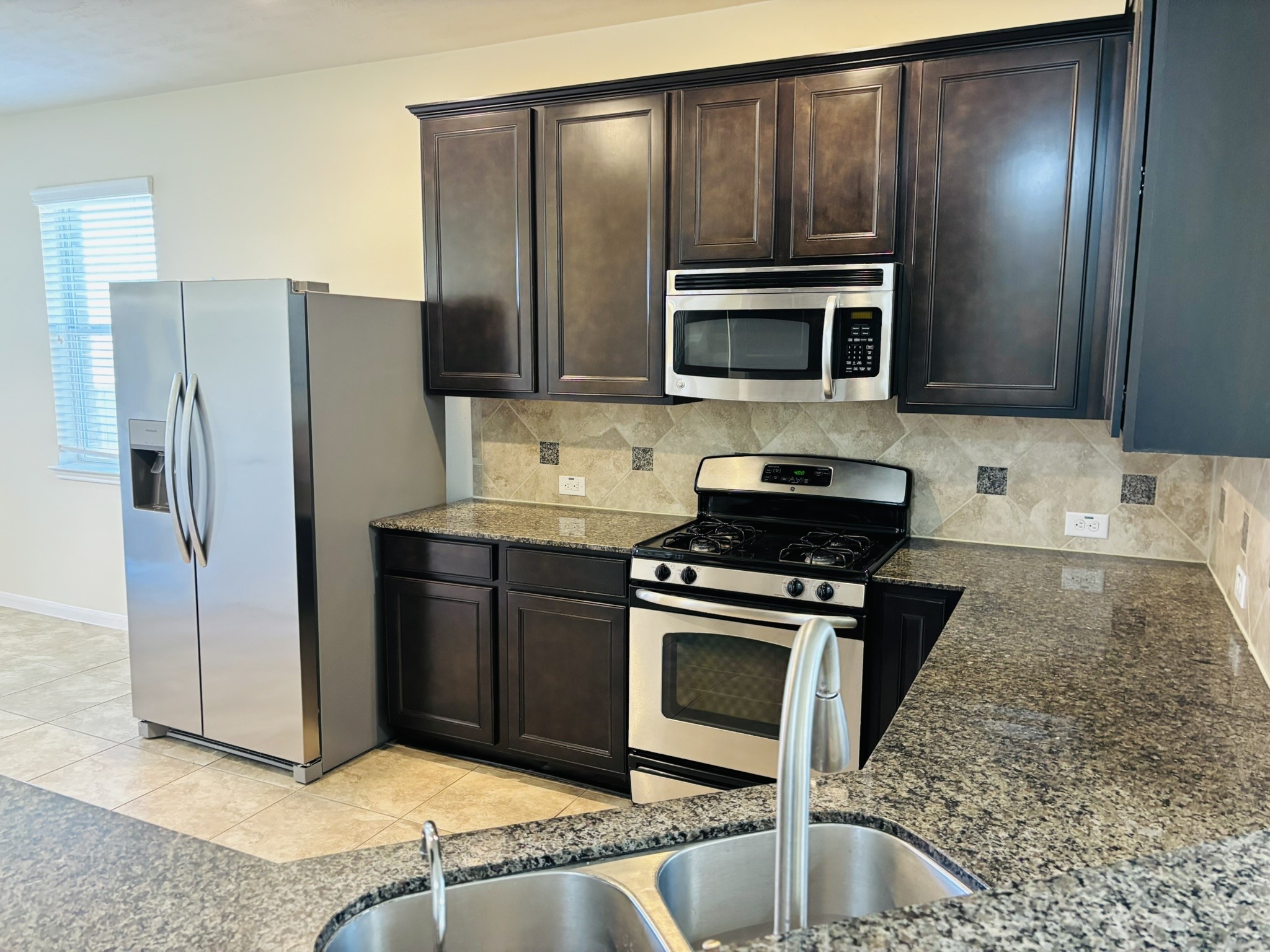 8525 Sunset Loch Drive Spring, TX 77379 - Photo 5 of 28 a kitchen with granite countertop a refrigerator and a stove top oven